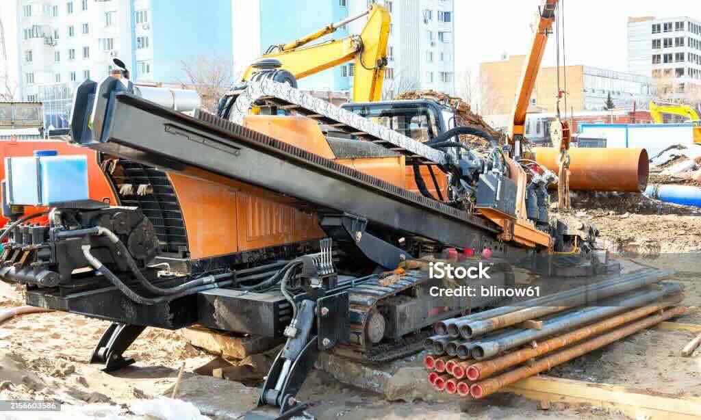 Small directional drill placing services beneath a residential driveway.